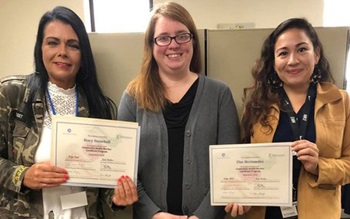 3 women smiling and displaying certificates